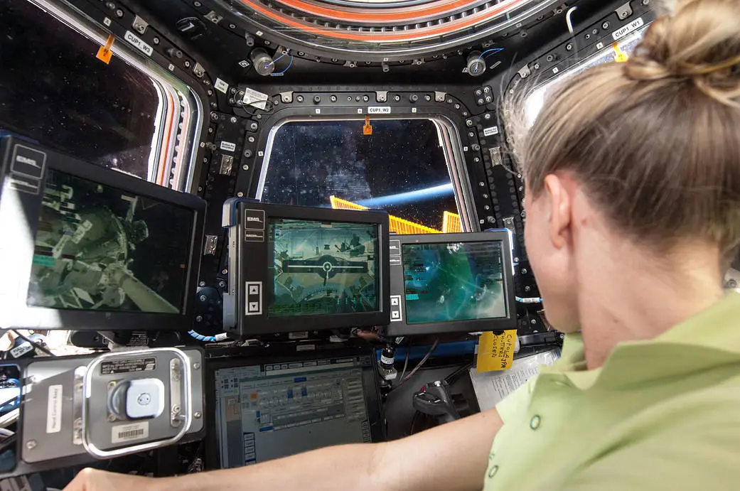 NASA astronaut Karen Nyberg at the robotics workstation in the International Space Station's Cupola during an onboard training session, illustrating the human-automation collaboration required for robotic operations in space.